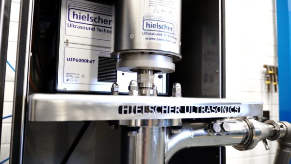High-power Hielscher ultrasonic processor installed inline for continuous dispersion of recycled plastic and crumb rubber into hot bitumen, enabling uniform mixing, improved binder stability, and scalable industrial asphalt modification.